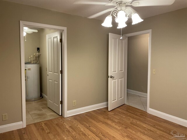 3036 Laurel Dr, Gulf Breeze, FL 32563 - unfurnished bedroom featuring water heater, light wood finished floors, a ceiling fan, and baseboards