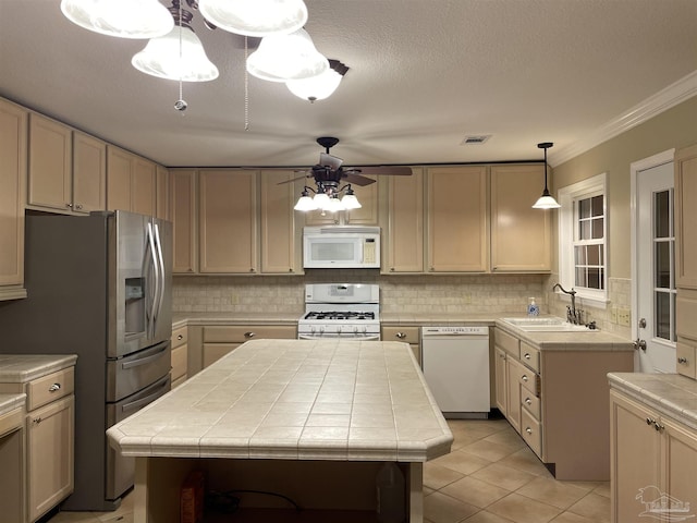 3036 Laurel Dr, Gulf Breeze, FL 32563 - kitchen featuring white appliances, tile counters, a sink, tasteful backsplash, and ornamental molding