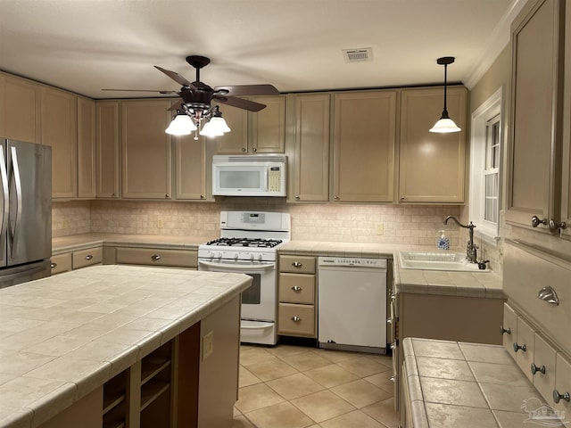 3036 Laurel Dr, Gulf Breeze, FL 32563 - kitchen featuring white appliances, a sink, tile countertops, ceiling fan, and backsplash