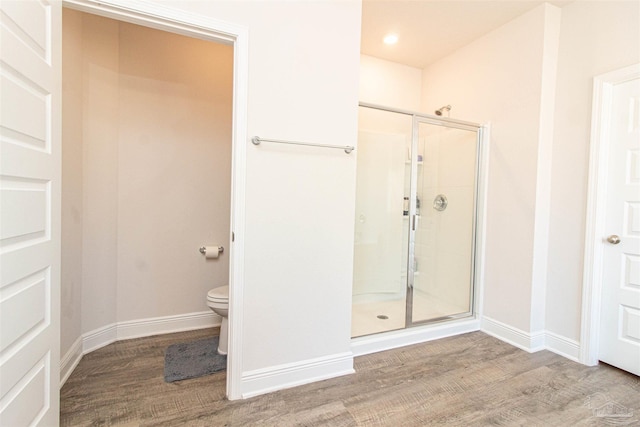 bathroom with an enclosed shower and hardwood / wood-style flooring