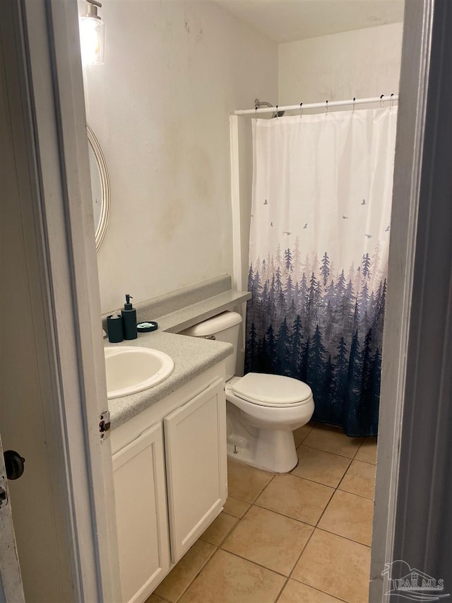 bathroom featuring toilet, tile patterned flooring, and vanity