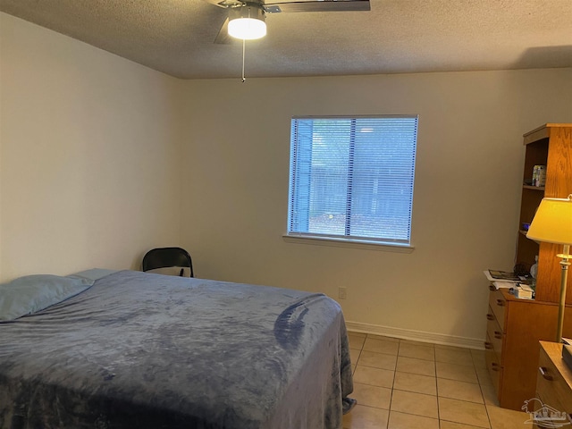 bedroom with light tile patterned floors, ceiling fan, and a textured ceiling