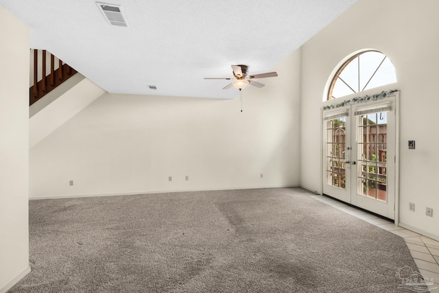 unfurnished room with light carpet, french doors, a textured ceiling, ceiling fan, and high vaulted ceiling