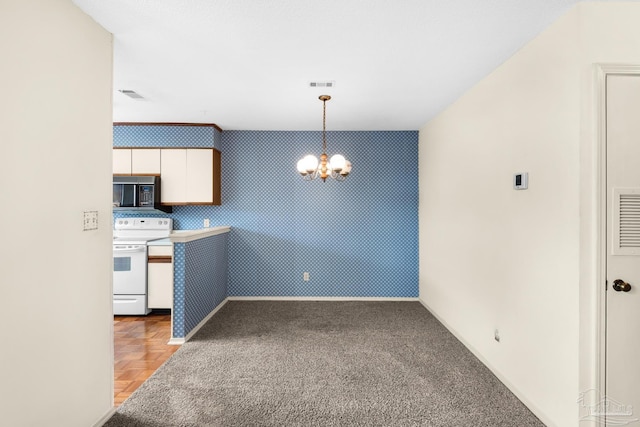 kitchen with carpet, white electric range oven, a notable chandelier, white cabinetry, and hanging light fixtures