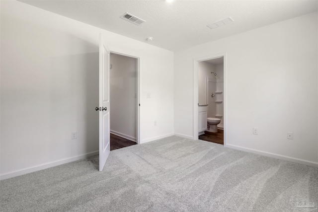 unfurnished bedroom featuring carpet, baseboards, and ensuite bathroom
