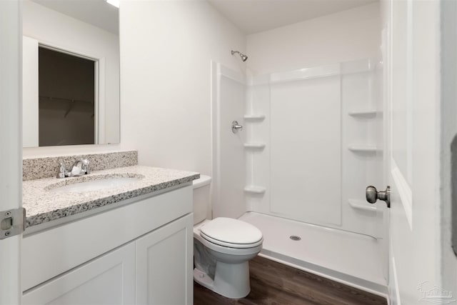 full bathroom with wood finished floors, a shower, vanity, and toilet
