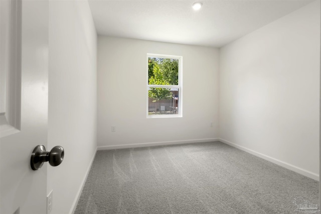 carpeted spare room with baseboards
