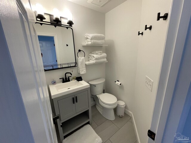 bathroom with tile patterned floors, baseboards, toilet, and vanity