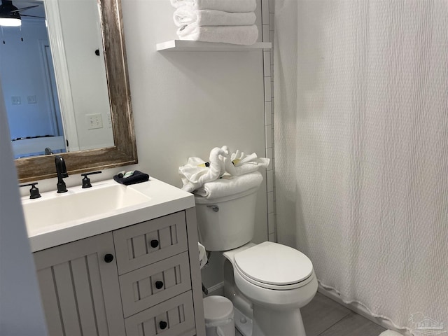 bathroom featuring curtained shower, toilet, and vanity