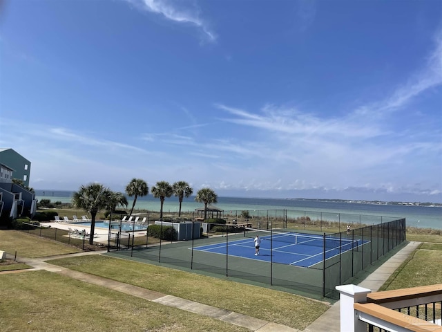 view of tennis court with a water view, a community pool, and fence