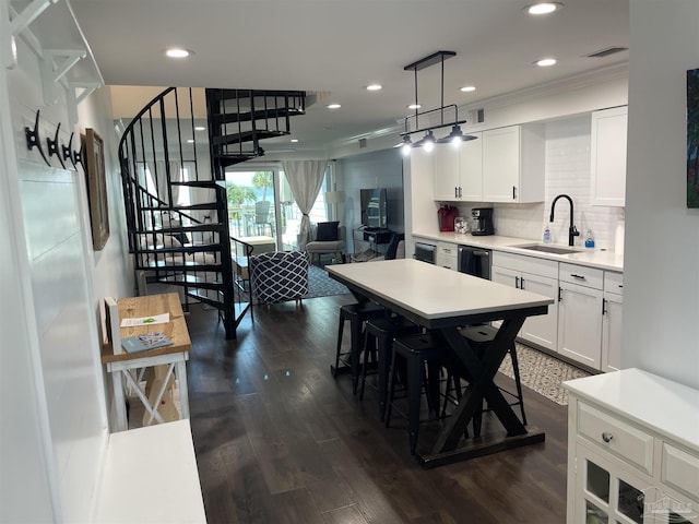 kitchen featuring a sink, tasteful backsplash, dark wood-style floors, and light countertops