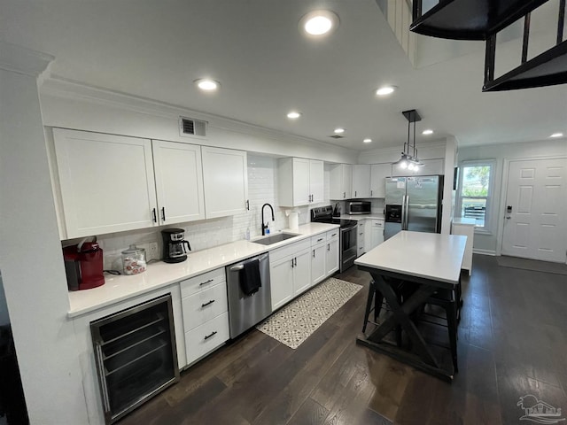 kitchen featuring beverage cooler, a sink, tasteful backsplash, stainless steel appliances, and dark wood-style flooring