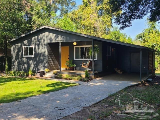 ranch-style home with a front lawn, a porch, and a carport