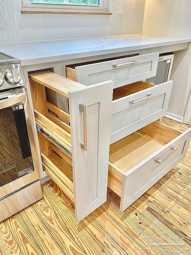 room details with light hardwood / wood-style flooring, white cabinetry, and stainless steel range