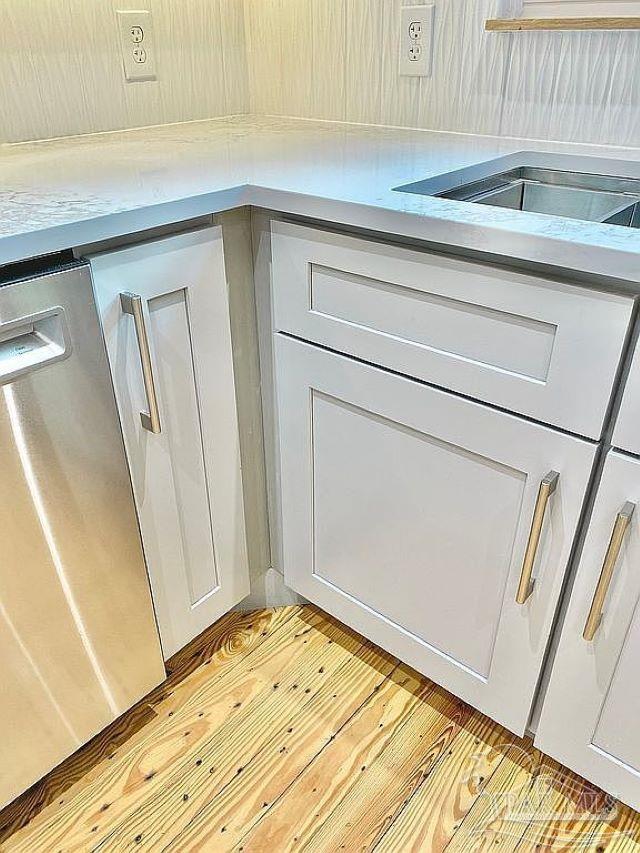 details featuring stainless steel dishwasher, light hardwood / wood-style floors, and white cabinets