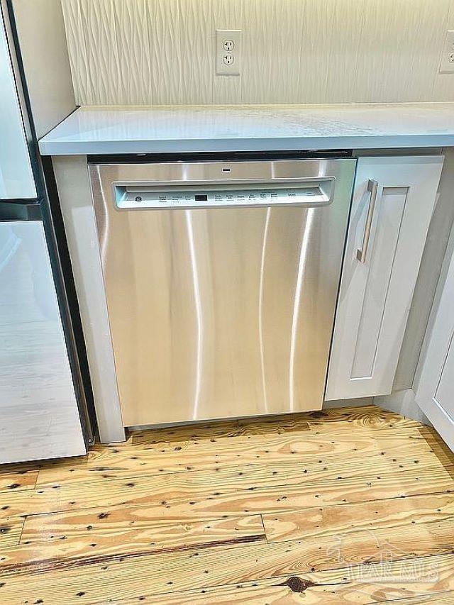 interior details featuring appliances with stainless steel finishes and light wood-type flooring