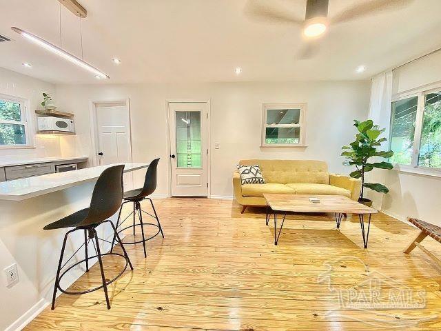 living room featuring ceiling fan and light wood-type flooring