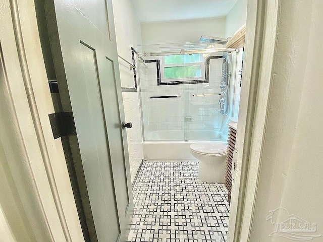 full bathroom featuring combined bath / shower with glass door, vanity, and toilet