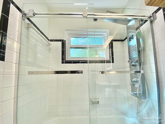 bathroom with shower / bath combination with glass door