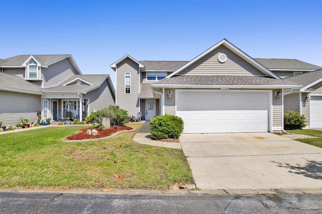 traditional-style house with an attached garage, a front lawn, concrete driveway, and roof with shingles