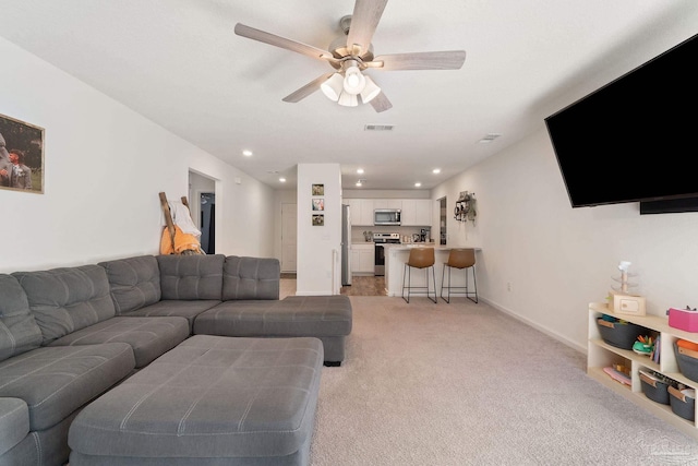 living area featuring light carpet, baseboards, visible vents, a ceiling fan, and recessed lighting