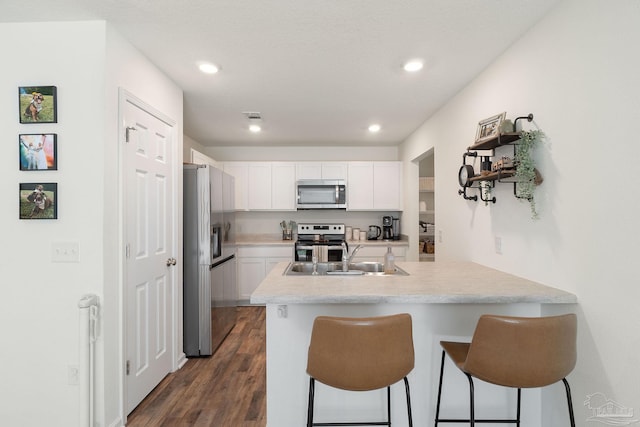 kitchen with a sink, appliances with stainless steel finishes, white cabinets, and light countertops