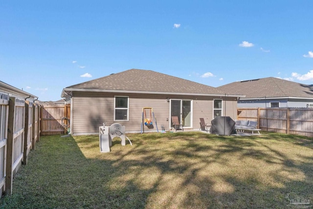 back of property featuring a shingled roof, a fenced backyard, a yard, and a patio