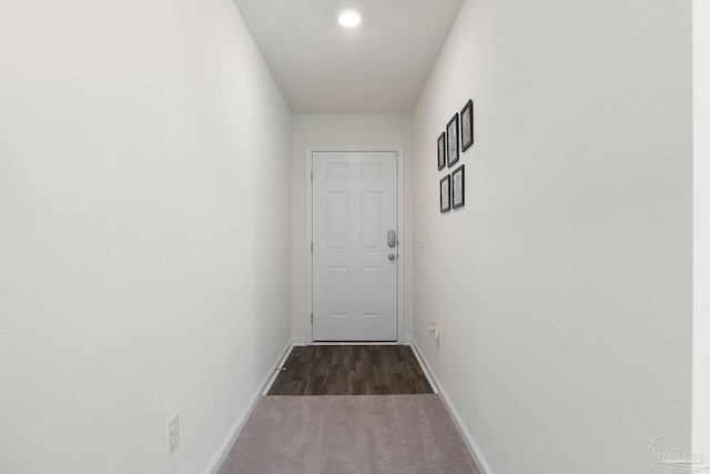 doorway with dark wood-style flooring and baseboards