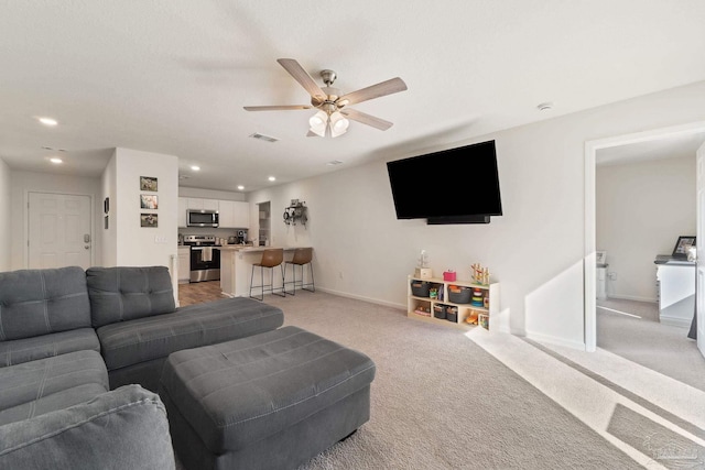 living room with recessed lighting, visible vents, and light colored carpet