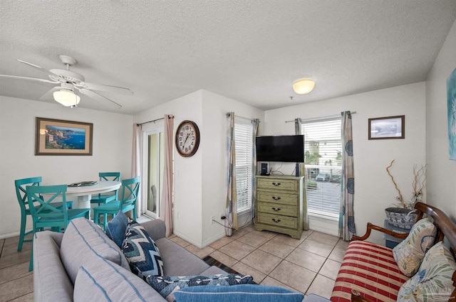 tiled living room featuring ceiling fan and a textured ceiling