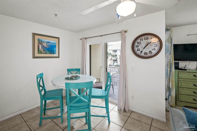 tiled dining space featuring ceiling fan and a textured ceiling