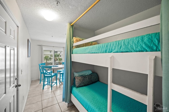 bedroom with light tile patterned floors and a textured ceiling