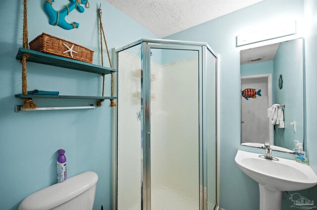 bathroom featuring sink, toilet, an enclosed shower, and a textured ceiling