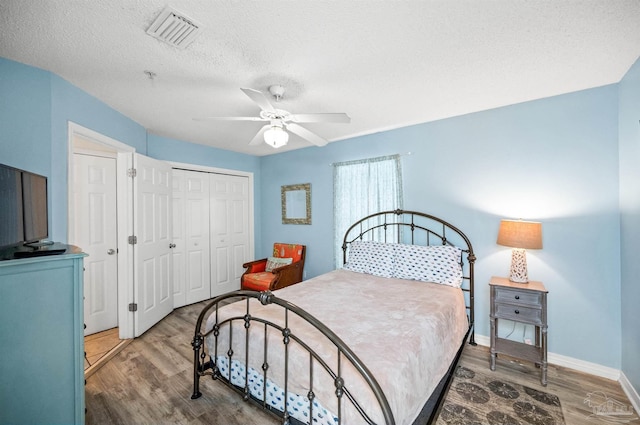 bedroom with a textured ceiling, a closet, hardwood / wood-style flooring, and ceiling fan