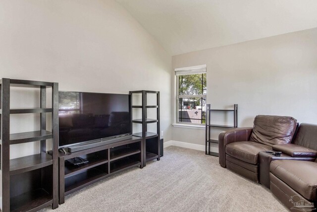 living room with baseboards, vaulted ceiling, and light colored carpet