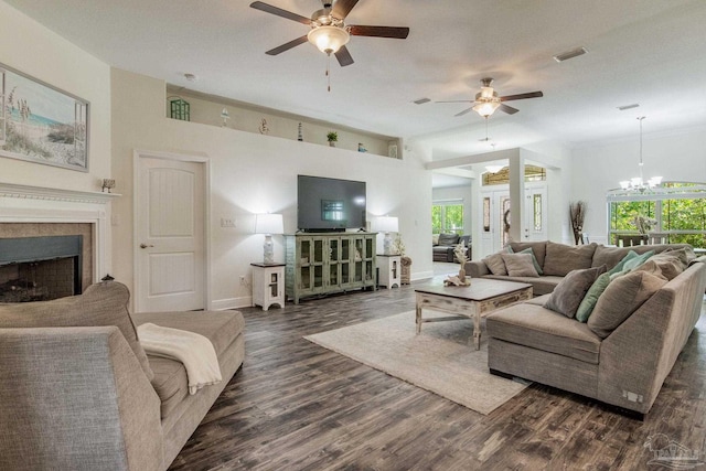 living room featuring ceiling fan with notable chandelier, plenty of natural light, and dark wood-type flooring