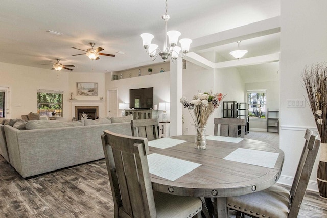 dining area with dark hardwood / wood-style floors and ceiling fan with notable chandelier