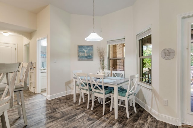 dining area with dark hardwood / wood-style flooring and a towering ceiling