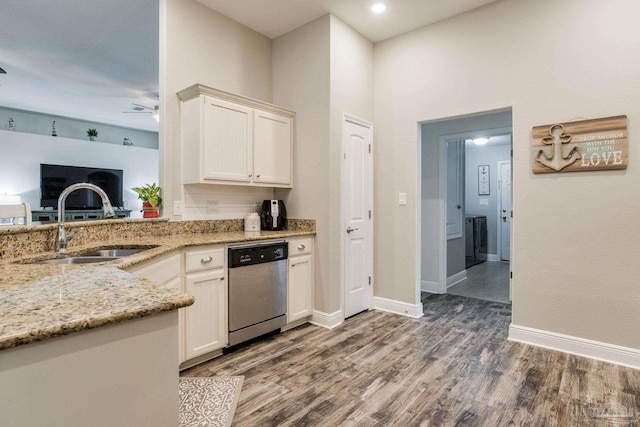 kitchen with light stone countertops, sink, ceiling fan, stainless steel dishwasher, and dark hardwood / wood-style floors