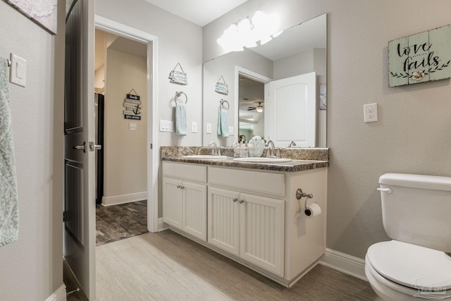 bathroom with toilet, vanity, and hardwood / wood-style flooring