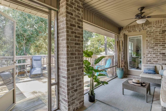 sunroom featuring ceiling fan and wooden ceiling