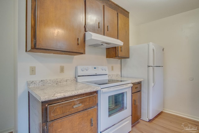 kitchen featuring white appliances and light hardwood / wood-style floors