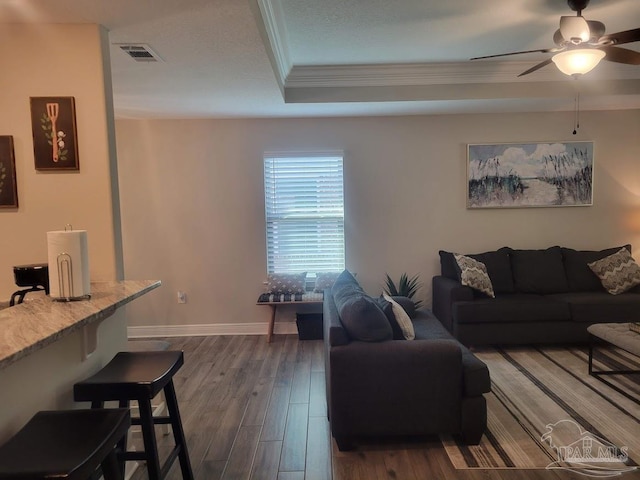 living room with hardwood / wood-style flooring, ceiling fan, and ornamental molding