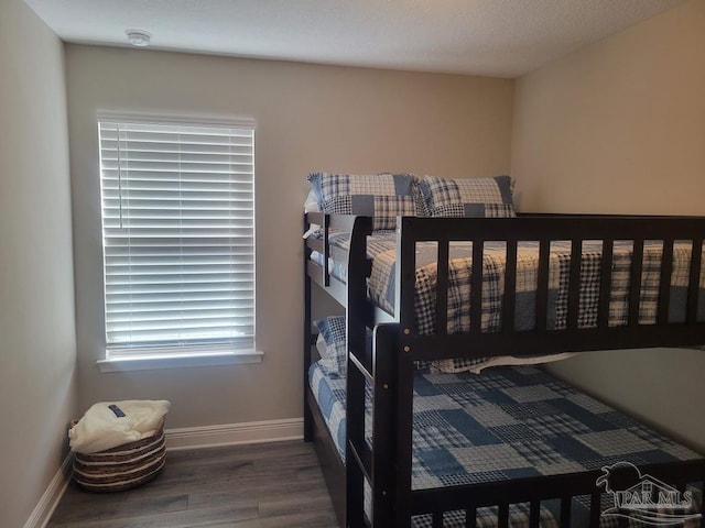 bedroom featuring a textured ceiling and dark hardwood / wood-style flooring