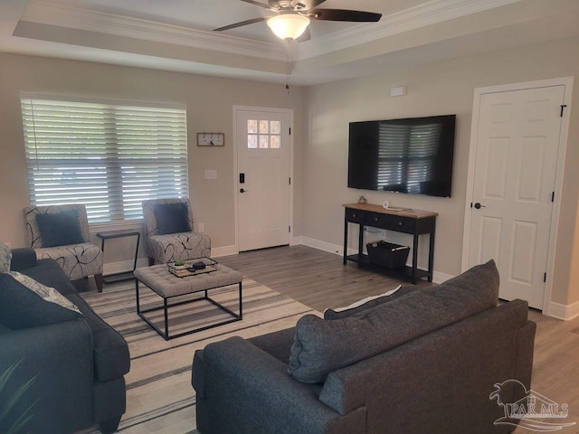 living room featuring hardwood / wood-style flooring, a raised ceiling, plenty of natural light, and ceiling fan