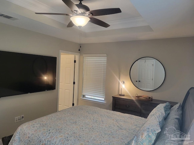 bedroom featuring ceiling fan, crown molding, and a tray ceiling