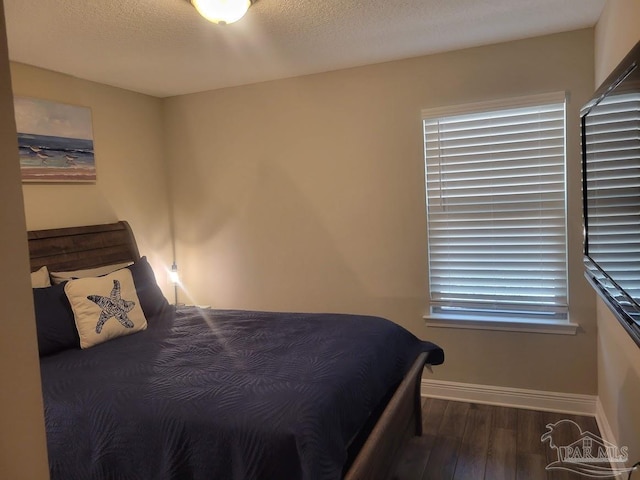 bedroom with hardwood / wood-style floors and a textured ceiling