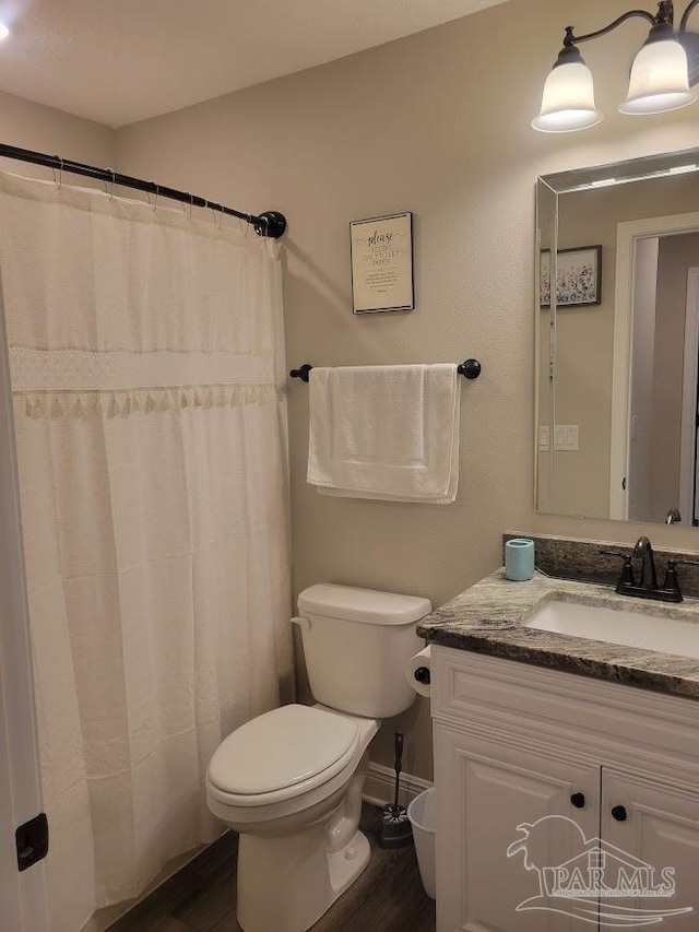 bathroom featuring vanity, wood-type flooring, and toilet