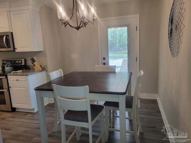 dining room with dark hardwood / wood-style flooring and a notable chandelier