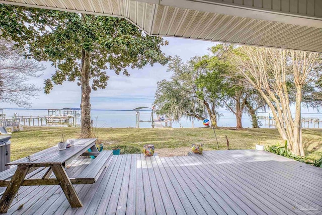 wooden deck with a water view and a lawn